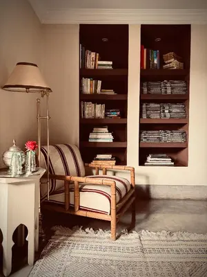 a living room with a chair and a book shelf at Riad Abracadabra in Marrakech