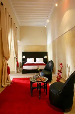 a bedroom with a bed and a red rug at Riad Dar Asam in Marrakech