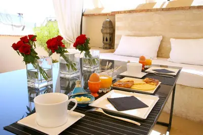 a tray of breakfast food on a table on a balcony at Riad Dar Asam in Marrakech