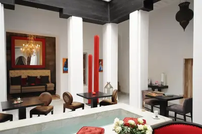 a living room with a pool and tables and chairs at Riad Dar Asam in Marrakech