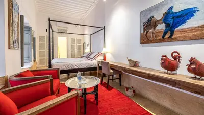 a living room with a bed and a table and chairs at Riad Dar Asam in Marrakech
