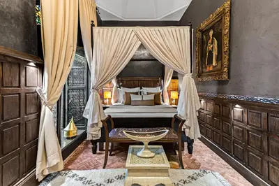 a bedroom with a canopy bed and a table at Riad ILayka in Marrakech