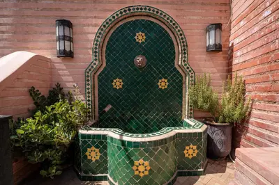 a green and gold door in the side of a building at Riad ILayka in Marrakech