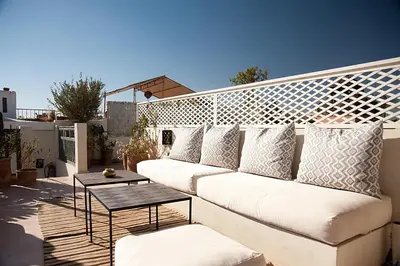 a white couch on a balcony with a table at Riad Le J in Marrakech