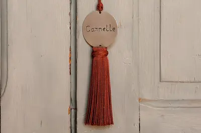 a red tie is hanging on a wooden door at Riad Le J in Marrakech