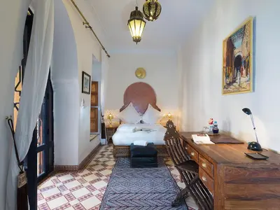 a bedroom with a bed and a desk and a desk at Riad Soundouss in Marrakech