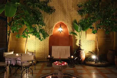 a room with a table and two trees and a lamp at Riad Soundouss in Marrakech