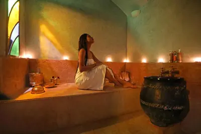 a woman sitting on a bath tub in a bathroom at Dar Kandi in Marrakech