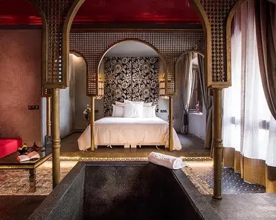 a bedroom with a large bed and a bath tub at Dar Kandi in Marrakech