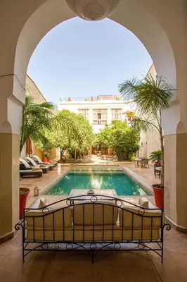 an archway leading to a swimming pool in a building at Riad Charaï in Marrakech