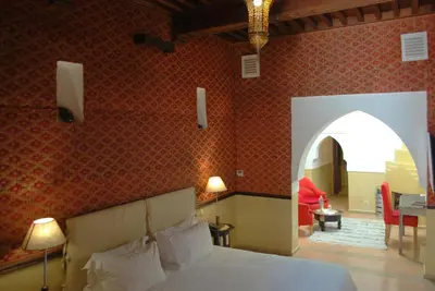 a bedroom with a bed and an archway in a room at Riad Charaï in Marrakech