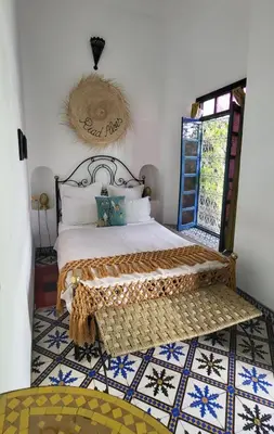 a bedroom with a bed with a rug on the floor at Riad Aloes & Spa in Marrakech