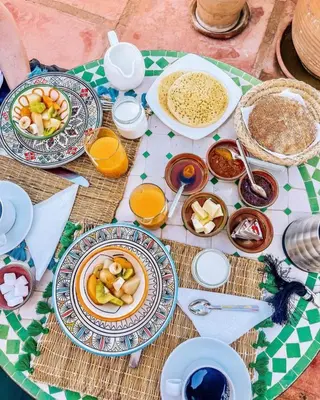 a table with plates and bowls of food on it at Riad Aloes & Spa in Marrakech