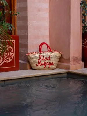 a basket sitting next to a pool of water at Riad Mazaya in Marrakech