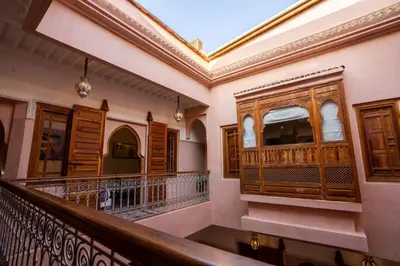 a balcony of a house with wooden doors andwindows at Riad Mazaya in Marrakech
