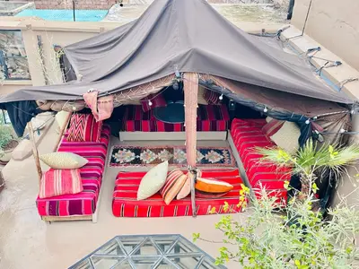 a group of red chairs under a tent at Berber Duchess Riad in Marrakech