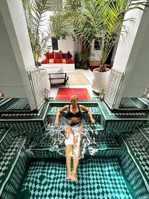 a woman standing in a swimming pool in a house at Berber Duchess Riad in Marrakech
