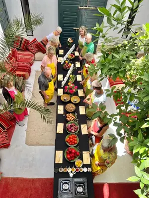 a group of people standing around a long table of food at Berber Duchess Riad in Marrakech