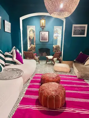a living room with a couch and two ottomans at Berber Duchess Riad in Marrakech
