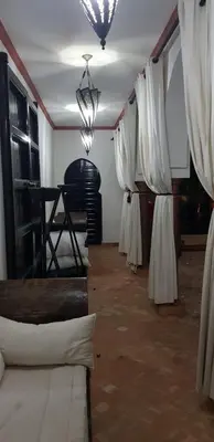 a room with white curtains and a room with tables at Villa avec piscine a Marrakech in Marrakech