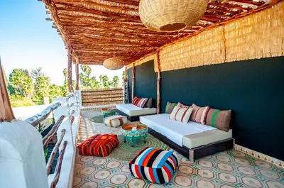 a porch with two beds and pillows on a patio at Riad Makila in Marrakech