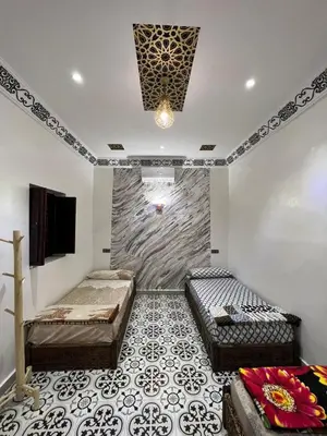 a room with two beds and a tv on the wall at For You Riad Marrakech in Marrakech