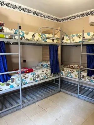 two bunk beds in a room with blue curtains at For You Riad Marrakech in Marrakech