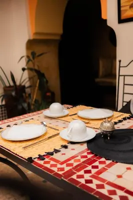 a table with white plates on top of a table at Riad Ajebel in Marrakech
