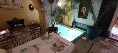 an overhead view of a pool with a table and plants at Riad Ajebel in Marrakech