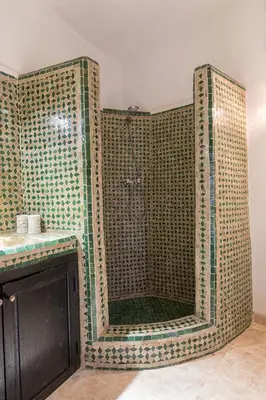 a bathroom with a shower with a tiled wall at Riad SASHA in Marrakech