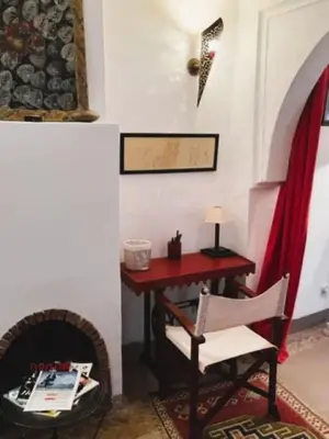 a room with a table and a chair and a desk at Riad SASHA in Marrakech