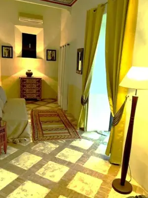 a living room with a couch and a lamp in a room at Riad SASHA in Marrakech