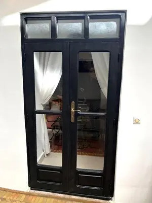 a black door with a window in a room at Riad SASHA in Marrakech