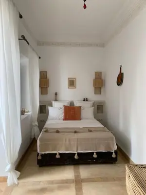 a bedroom with a bed in a white room at Riad Sin in Marrakech