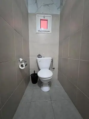 a bathroom with a white toilet and a window at Dar Tariq 3 suites avec pisicine in Marrakech