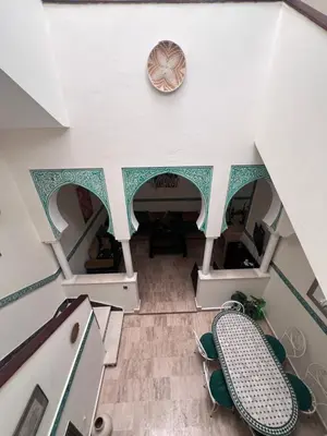 an overhead view of a living room with a clock on the wall at Dar Tariq 3 suites avec pisicine in Marrakech