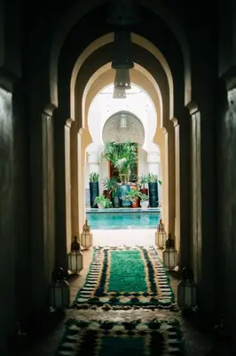 an archway with a rug in a hallway with plants at Riad Nashira & Spa in Marrakech