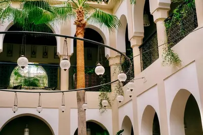 a palm tree in the middle of a building with lights at Riad Nashira & Spa in Marrakech