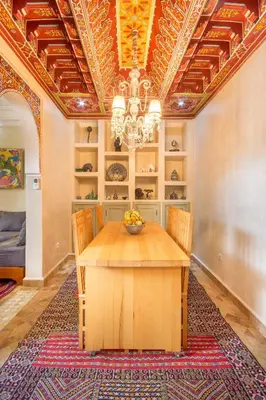 a dining room with a table and a chandelier at Riad Privé De Luxe Au Coeur De La Kasbah Avec Hammam in Marrakech