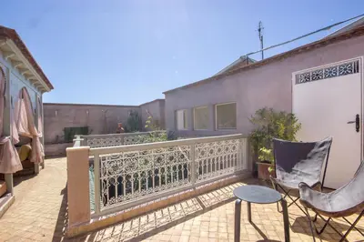 a balcony with a fence and a table and chairs at Riad Privé De Luxe Au Coeur De La Kasbah Avec Hammam in Marrakech