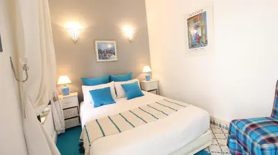 a bedroom with a large white bed with blue pillows at Riad Kasbah Baraka in Marrakech