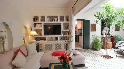 a living room with a white couch and a tv at Riad Kasbah Baraka in Marrakech