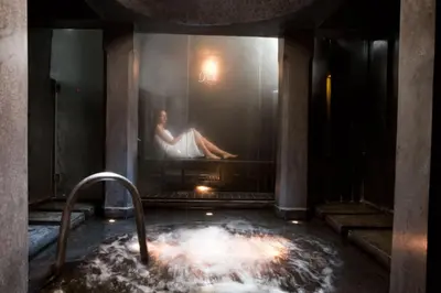 a woman sitting on a painting in a bath tub at Riad Alkaderi in Marrakech
