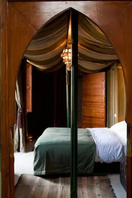 a bedroom with a canopy bed in a room at Riad Alkaderi in Marrakech