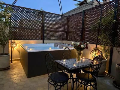a patio with a table and a hot tub at Riad ART DE VIVRE avec Jacuzzi in Marrakech