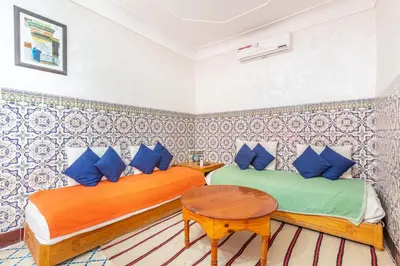 a bedroom with two beds and a table at Exclusive private Riad in Marrakech