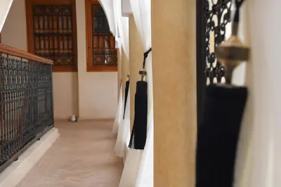 a hallway with black and white curtains in a building at Riad Berenssi in Marrakech