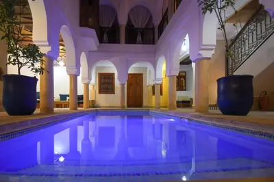 an indoor swimming pool in a building with a house at Riad Berenssi in Marrakech