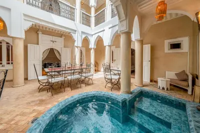 an indoor pool in a mansion with a table and chairs at RIAD AWINATI Location Privatisée ,piscine chauffée , beau Rooftop in Marrakech