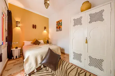 a bedroom with a bed and a large white door at RIAD AWINATI Location Privatisée ,piscine chauffée , beau Rooftop in Marrakech